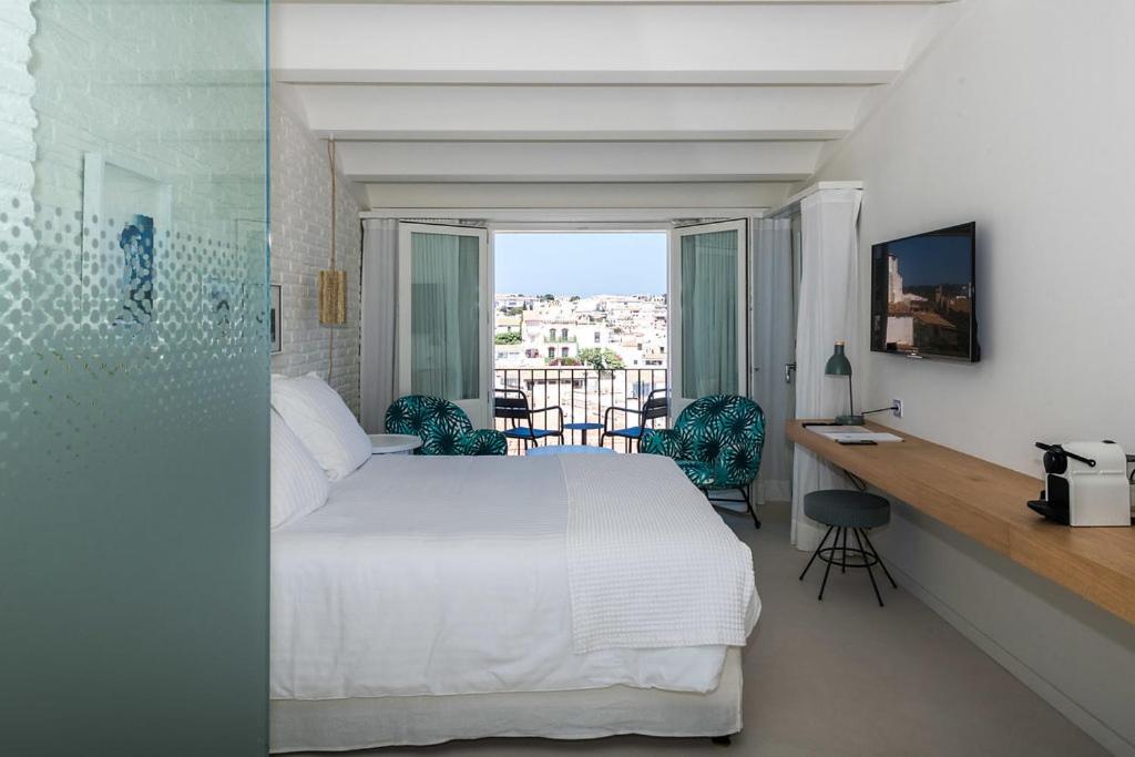 Un dormitorio con una cama blanca y un balcón. en Boutique Hotel Villa Gala by Fimedhotels, en Cadaqués 97 fotos más
