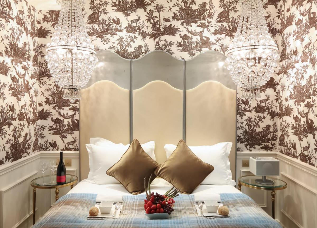 - une chambre avec un lit doté d'une grande tête de lit dans l'établissement La Maison Favart, à Paris
