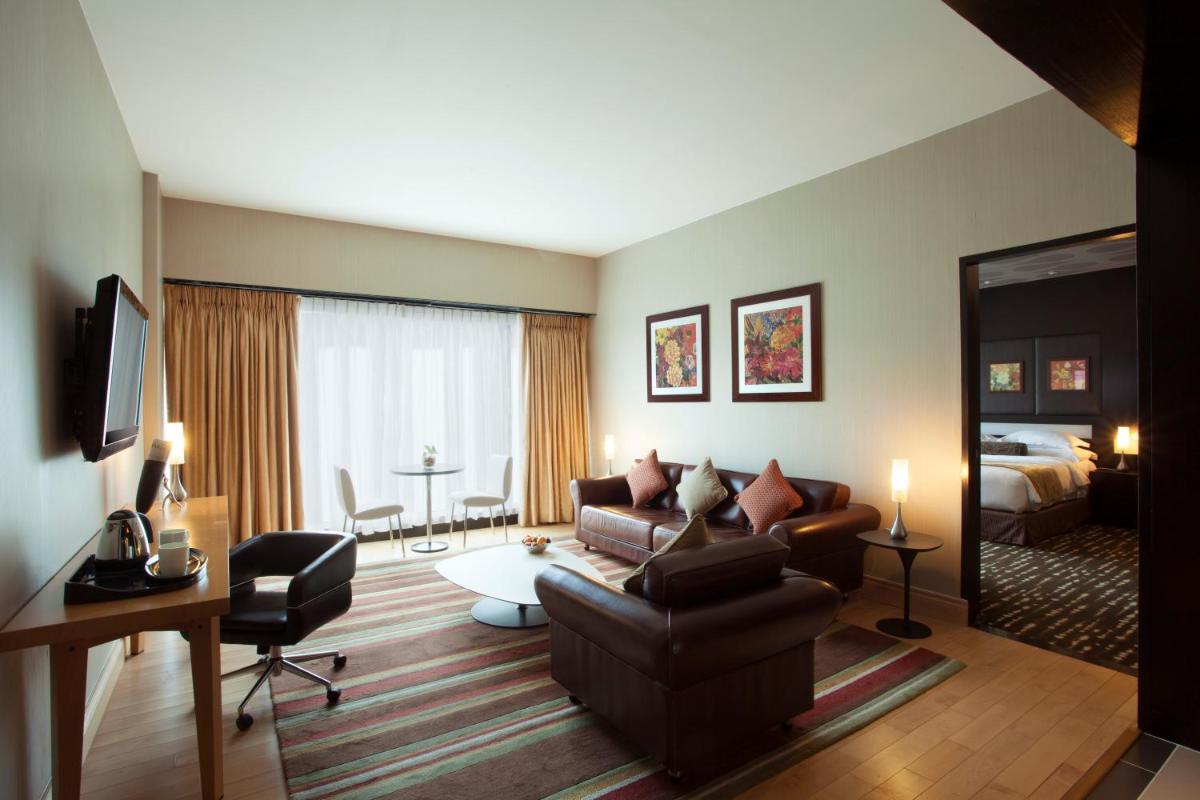 a living room with a couch and a bed at The Oterra in Bengaluru