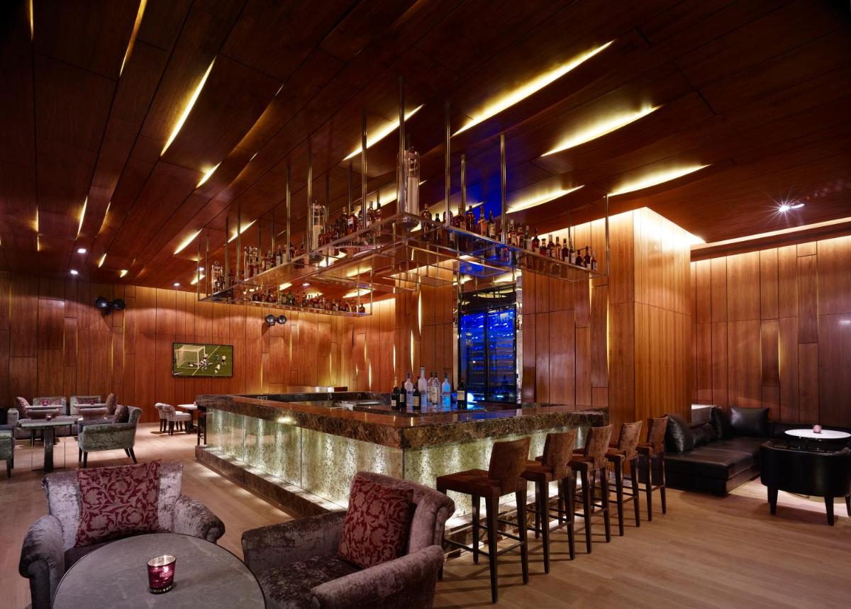 a bar in a restaurant with a bunch of chairs at Taj City Centre Gurugram in Gurgaon