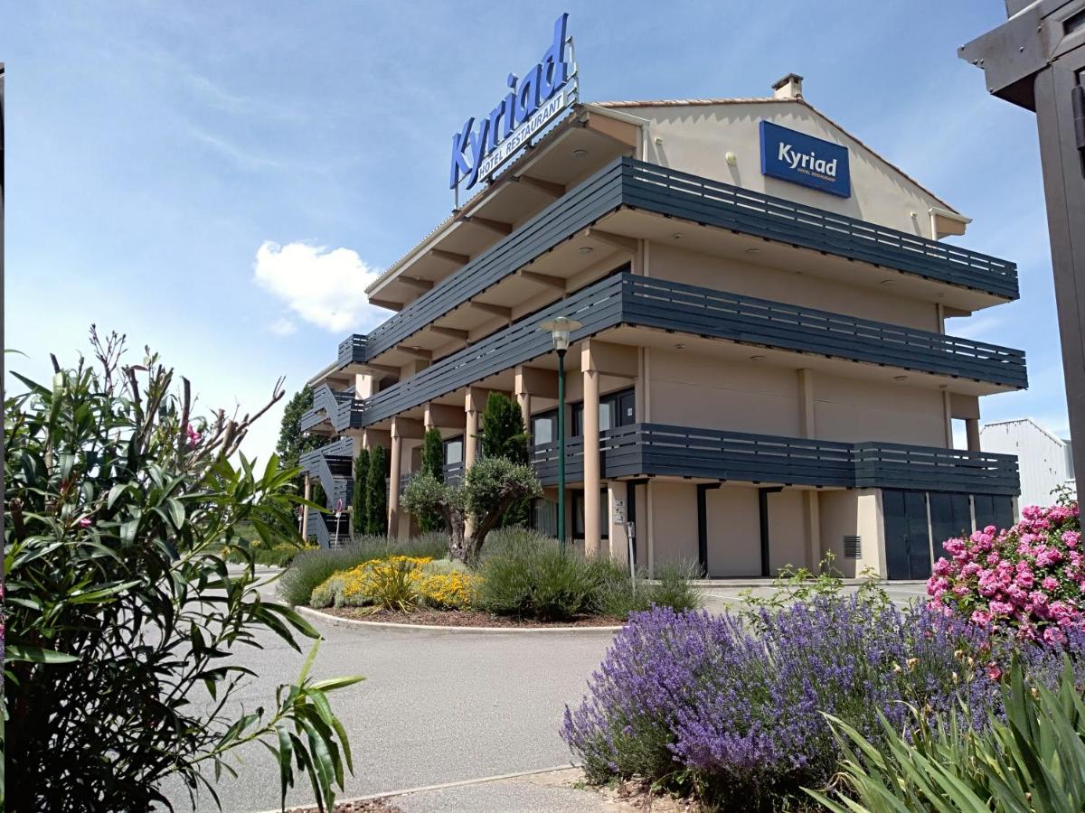 un hôtel avec une enseigne sur le devant dans l'établissement Kyriad Carcassonne - Aéroport, à Carcassonne