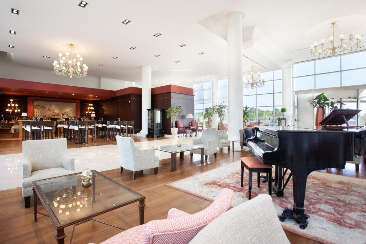 sala de estar con piano y restaurante en Grupotel Playa de Palma Suites & Spa, en Playa de Palma