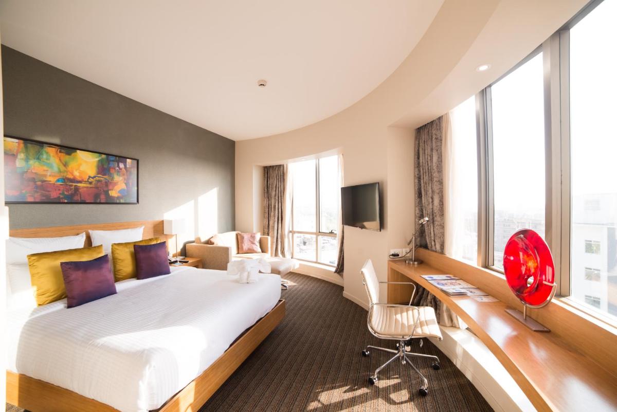 a hotel room with a bed and a desk at Novotel Lucknow Gomti Nagar in Lucknow