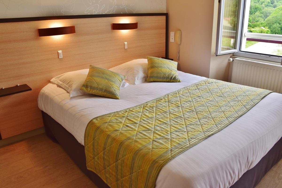 une chambre avec un grand lit avec deux oreillers dans l'établissement Logis Hôtel Bellevue, à Bessines-sur-Gartempe