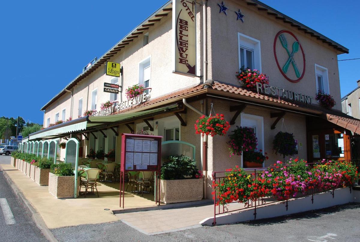 un bâtiment avec des fleurs en face, dans une rue dans l'établissement Logis Hôtel Bellevue, à Bessines-sur-Gartempe