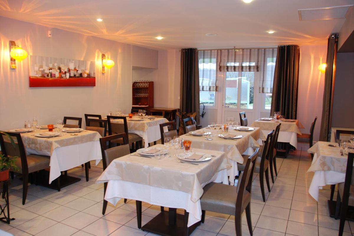 un restaurant avec tables et chaises et nappes blanches dans l'établissement Logis Hôtel Bellevue, à Bessines-sur-Gartempe
