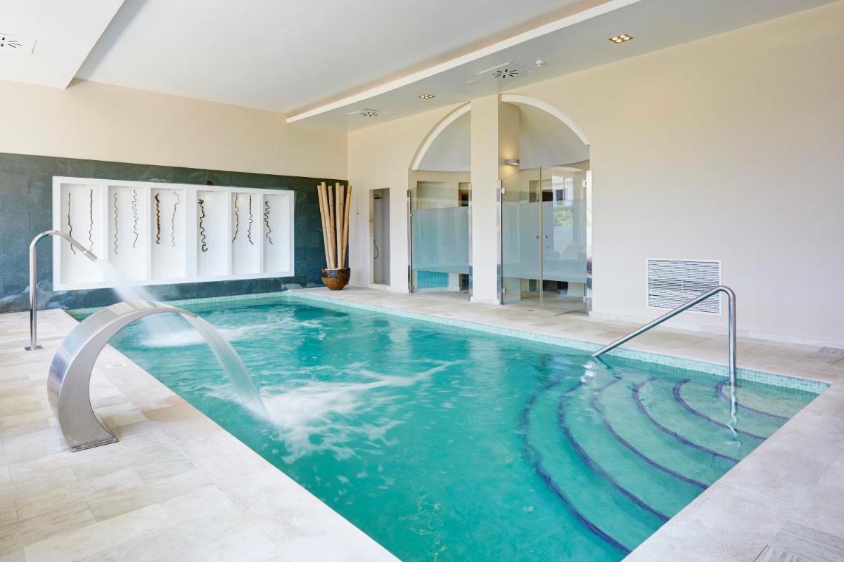 una gran piscina en una habitación con piscina en Grupotel Macarella Suites & Spa, en Son Xoriguer