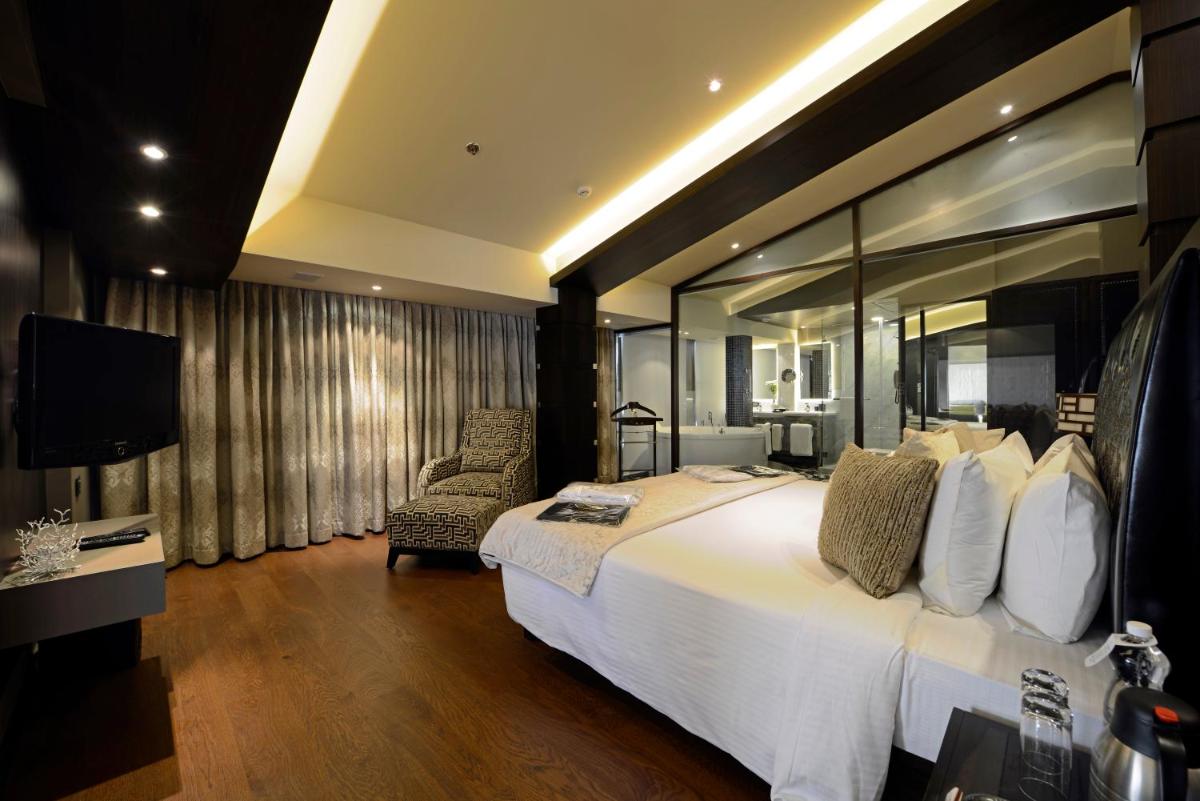 a hotel room with a large bed and a television at Sun-n-Sand Mumbai Juhu Beach in Mumbai