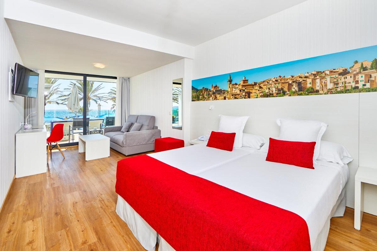 Un dormitorio con una cama grande con una manta roja. en Hotel Negresco - Adults Only, en Playa de Palma