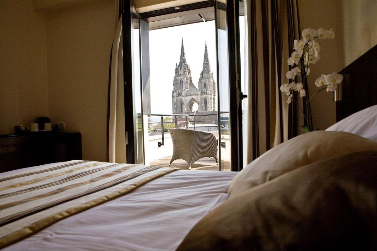une chambre avec un lit et vue sur une église dans l'établissement Best Western Plus Hotel des Francs, à Soissons 35 autres photos