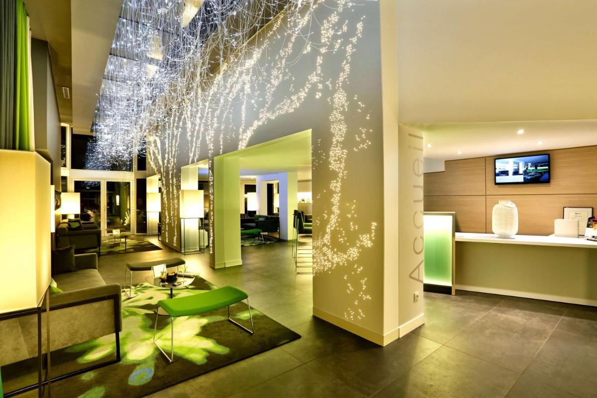 un hall d'un immeuble avec des lumières sur le mur dans l'établissement Best Western Plus Hotel Du Parc Chantilly, à Chantilly