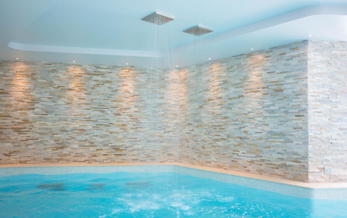 une piscine avec un mur en briques dans l'établissement Les Terrasses d'Eze - Hôtel & Spa, à Èze