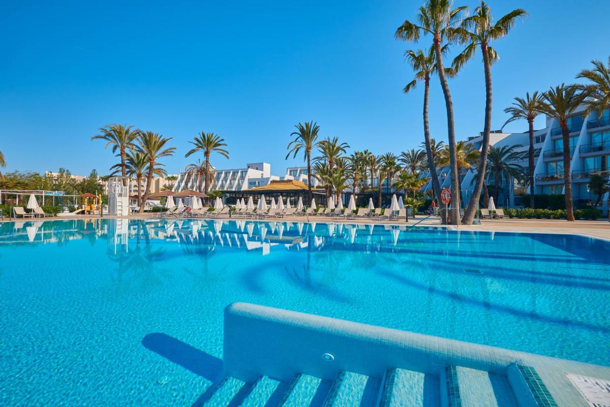 una piscina con un banco en un complejo en Protur Sa Coma Playa Hotel & Spa, en Sa Coma