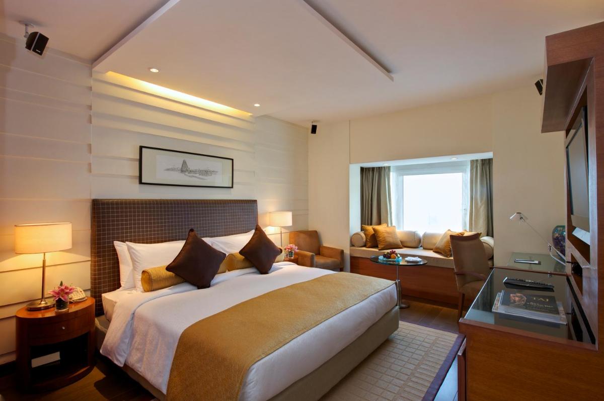 a hotel room with a bed and a couch at Taj Coromandel in Chennai