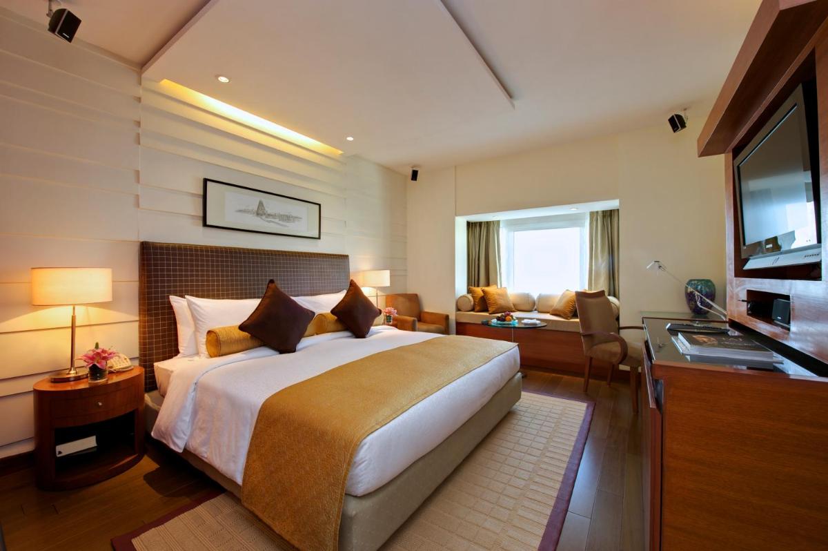 a hotel room with a bed and a living room at Taj Coromandel in Chennai
