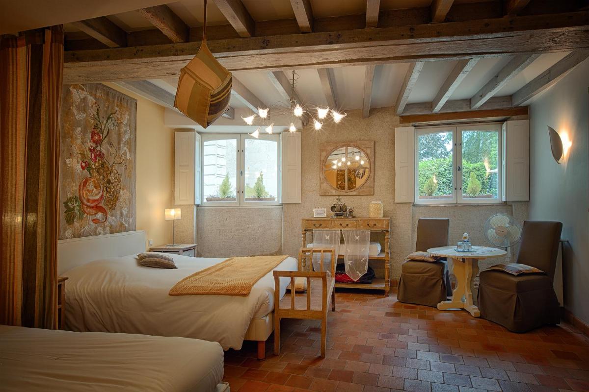 une chambre avec deux lits et une table dans l'établissement Hôtel & Spa Chai De La Paleine, à Le Puy-Notre-Dame
