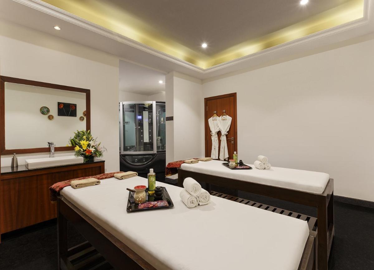a bathroom with two beds and a sink and a mirror at La Marvella, Bengaluru in Bengaluru a bathroom with two beds and a sink and a mirror at La Marvella, Bengaluru in Bengaluru
