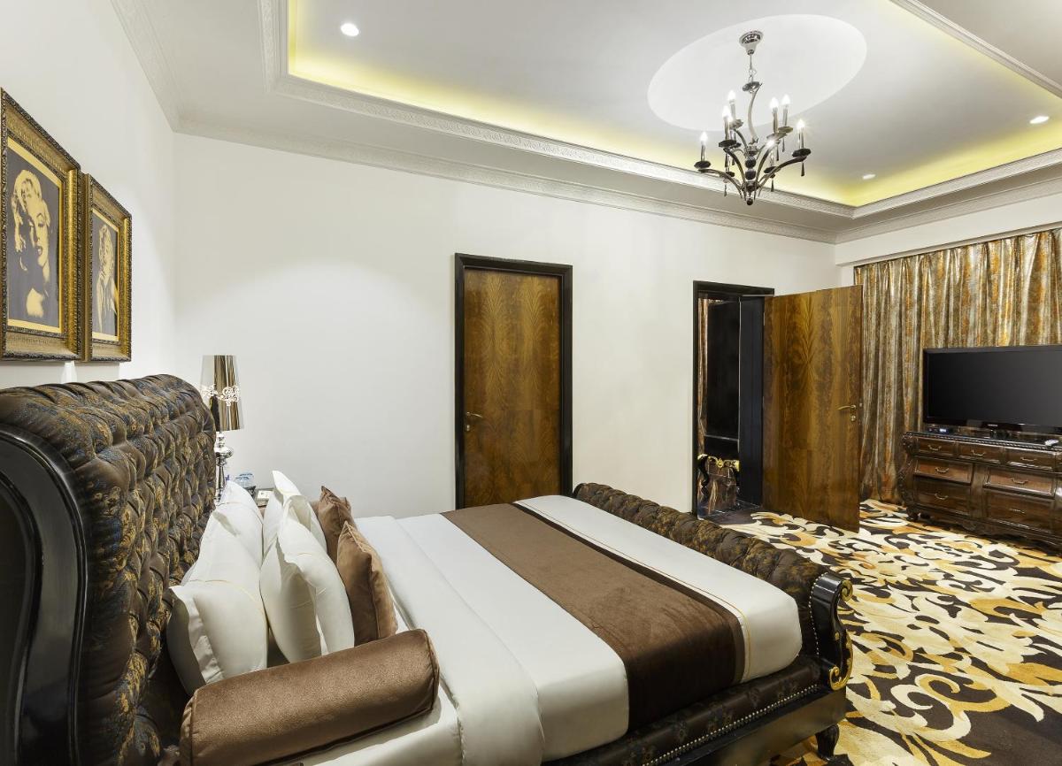 a hotel room with a bed and a television at La Marvella, Bengaluru in Bengaluru