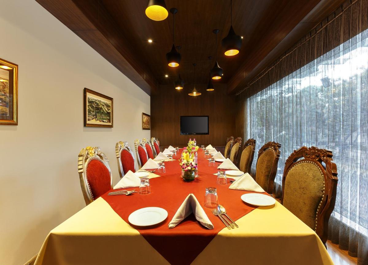 a conference room with a long table and chairs at La Marvella, Bengaluru in Bengaluru