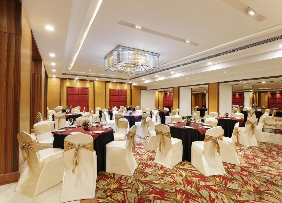a banquet hall with tables and chairs in a room at La Marvella, Bengaluru in Bengaluru