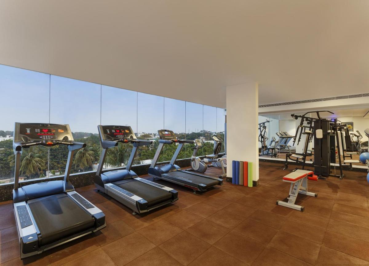 a gym with treadmills and ellipticals in a building at La Marvella, Bengaluru in Bengaluru