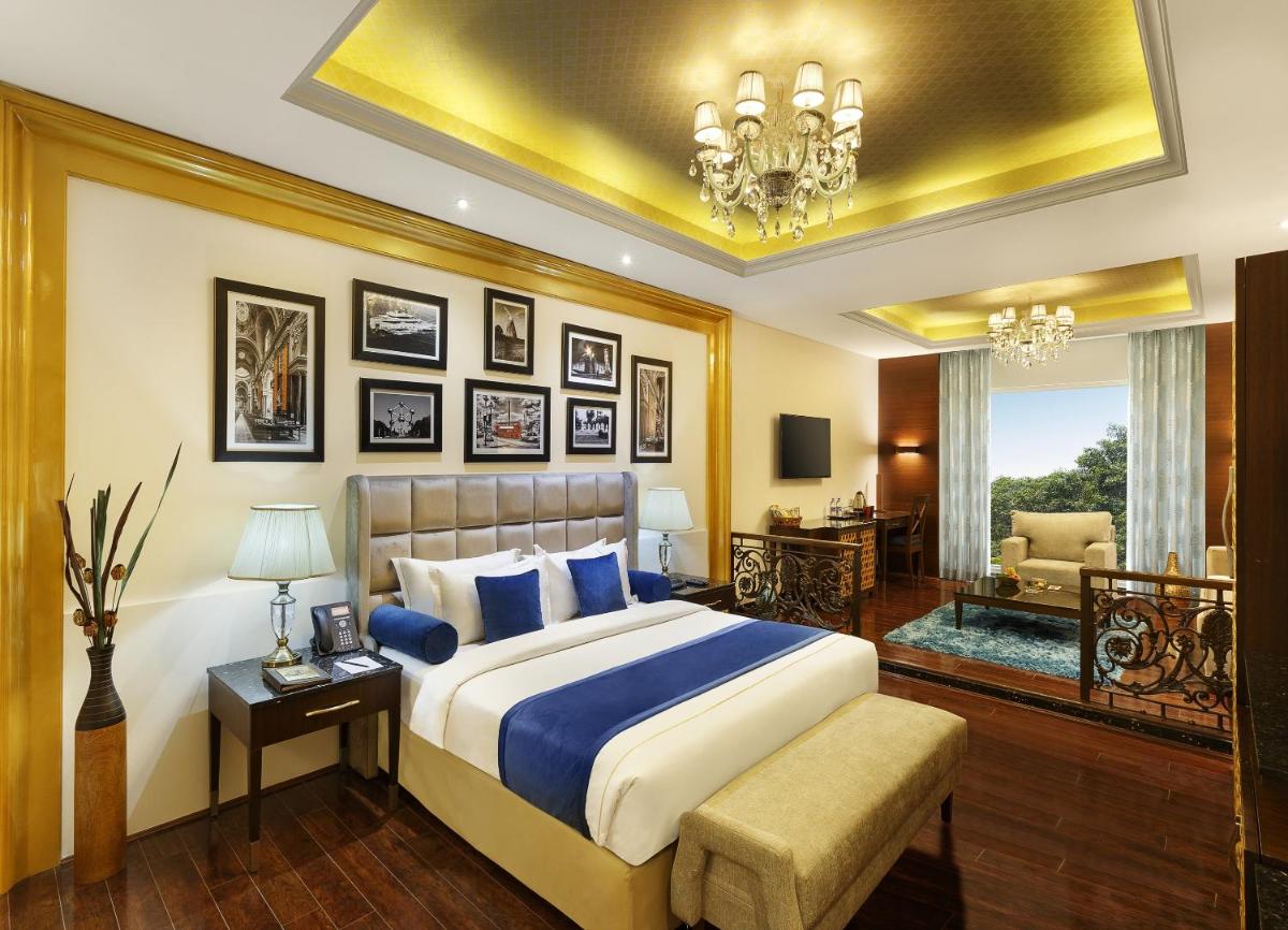 a bedroom with a large bed and a living room at La Marvella, Bengaluru in Bengaluru