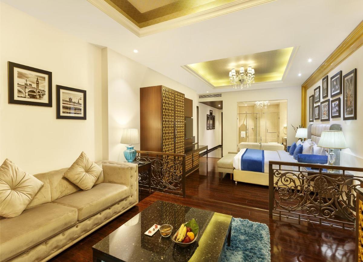a living room with a couch and a bed at La Marvella, Bengaluru in Bengaluru