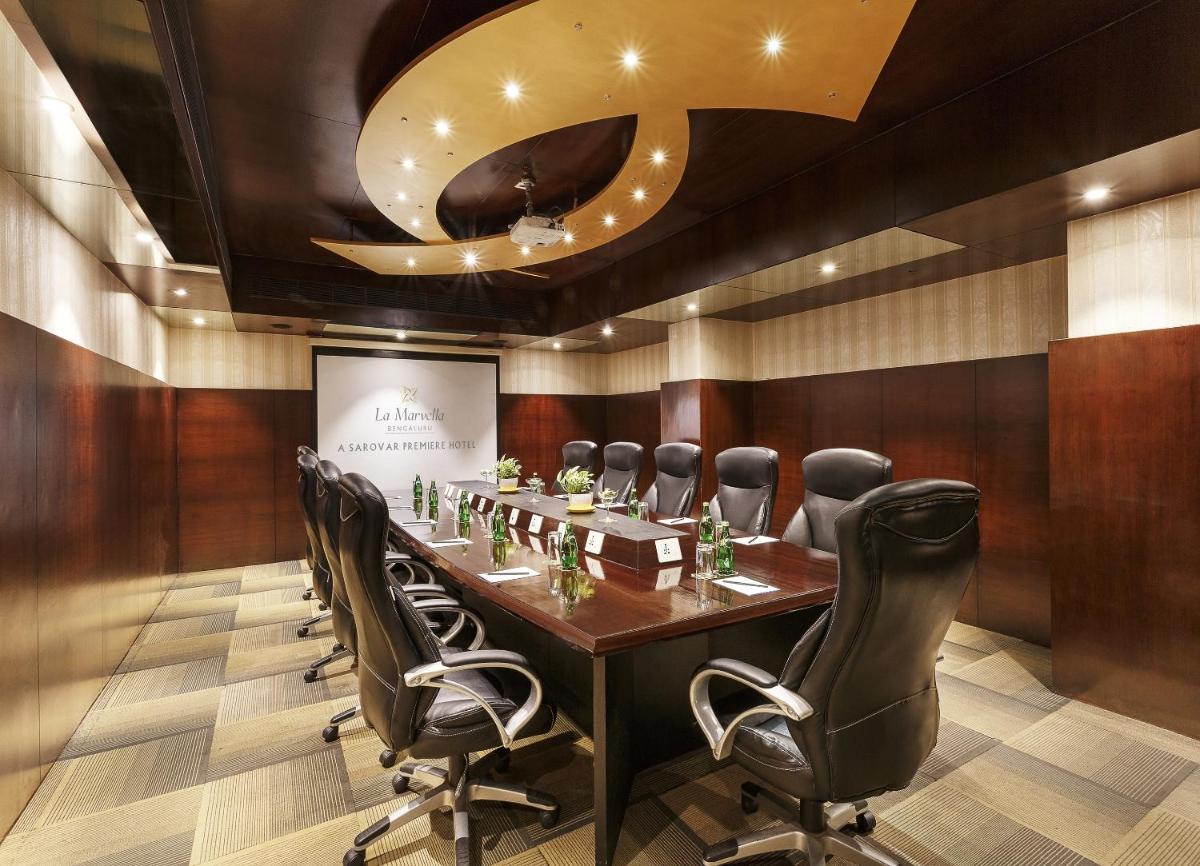 a conference room with a long table and chairs at La Marvella, Bengaluru in Bengaluru