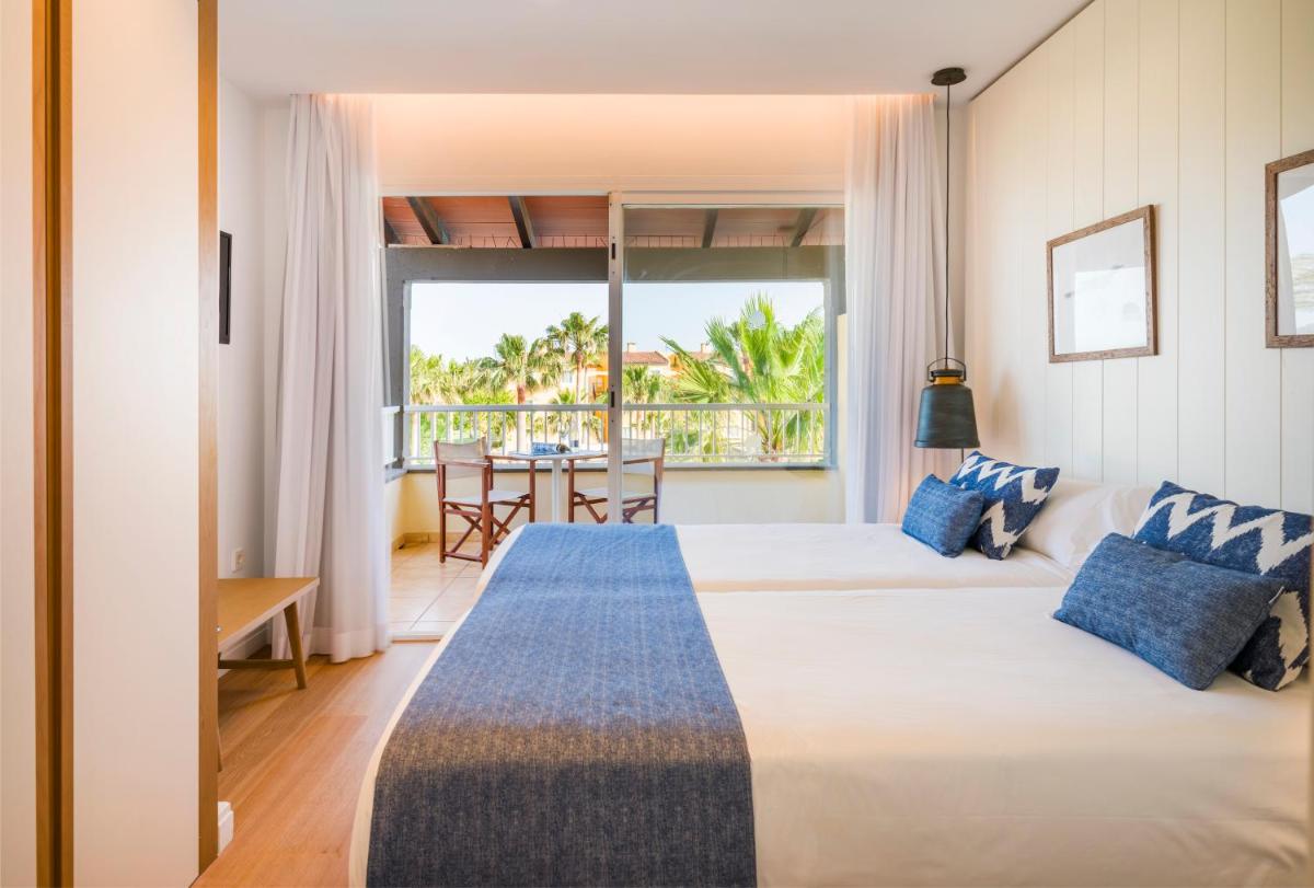 Un dormitorio con una cama grande y una ventana grande. en Club del Sol Aparthotel, en Puerto Pollensa