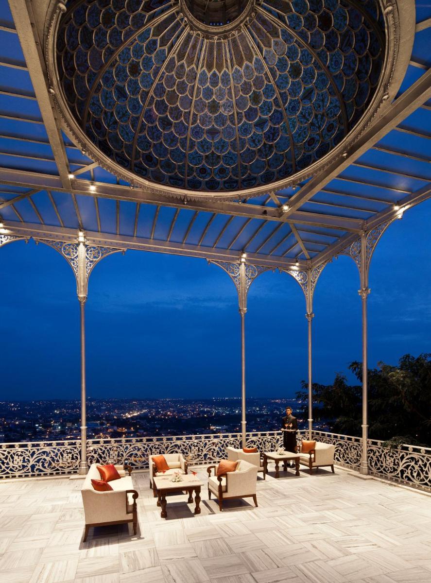 a room with chairs and tables and a ceiling at Taj Falaknuma Palace in Hyderabad