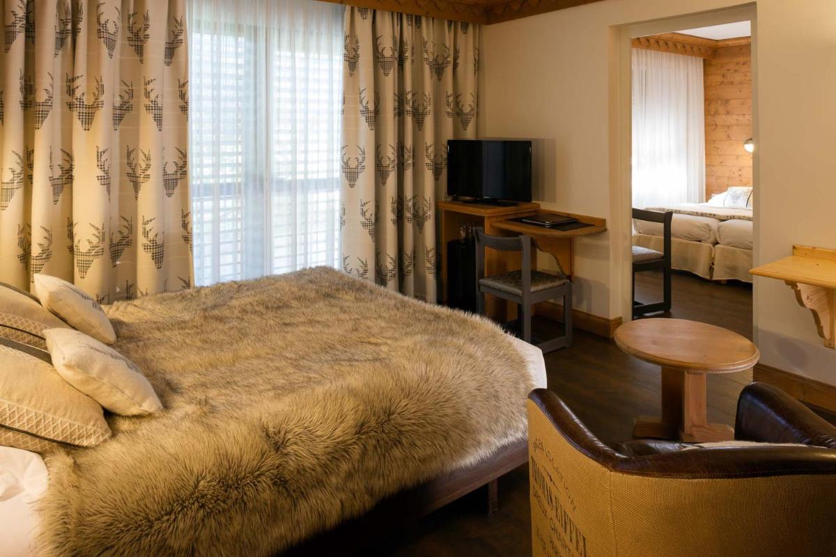 une chambre d'hôtel avec un lit et une télévision dans l'établissement Hotel le Chalet, à Gresse-en-Vercors