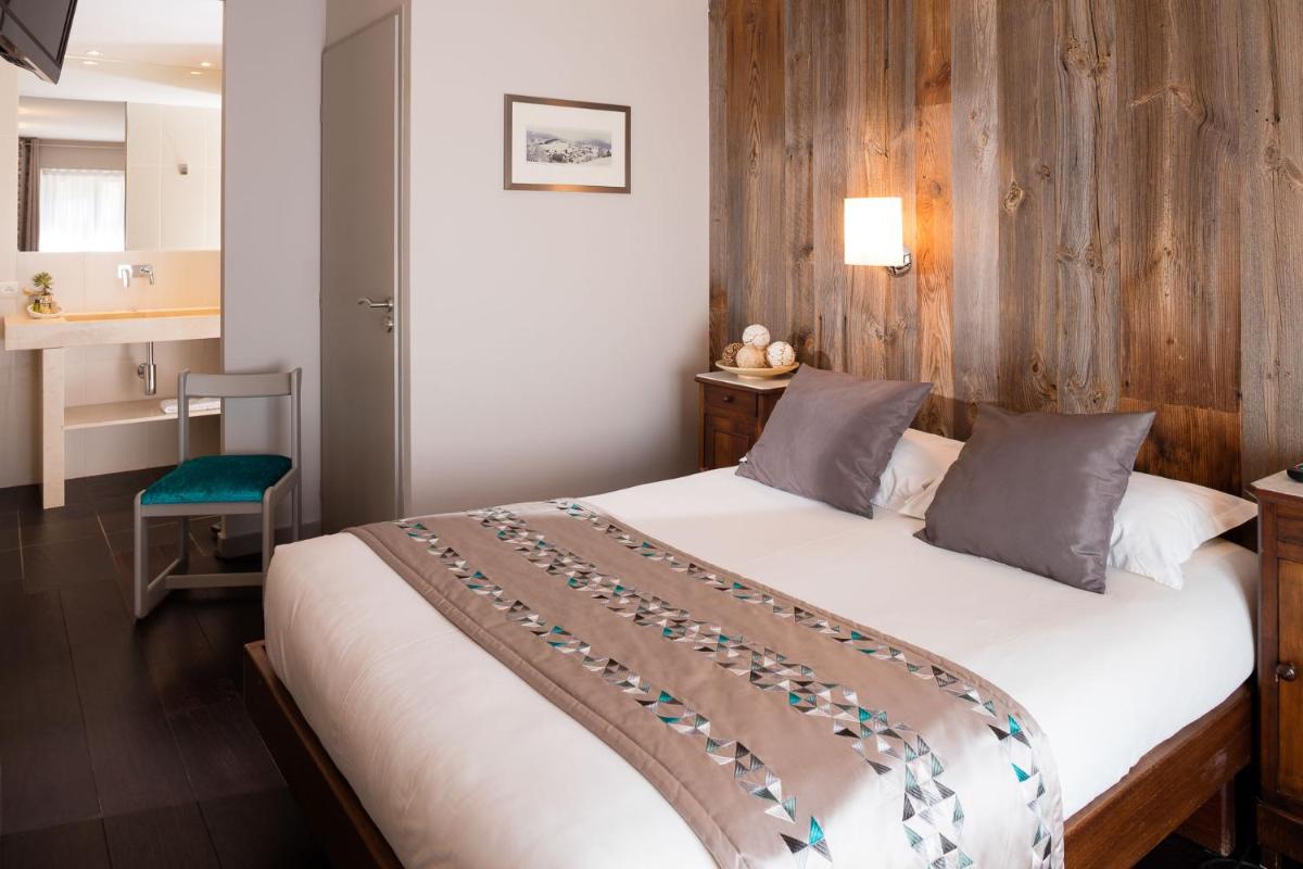 une chambre avec un lit et un mur en bois dans l'établissement Hotel le Chalet, à Gresse-en-Vercors 63 autres photos