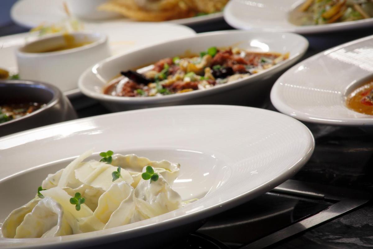 a group of plates of food on a table at Novotel Chennai Chamiers Road in Chennai