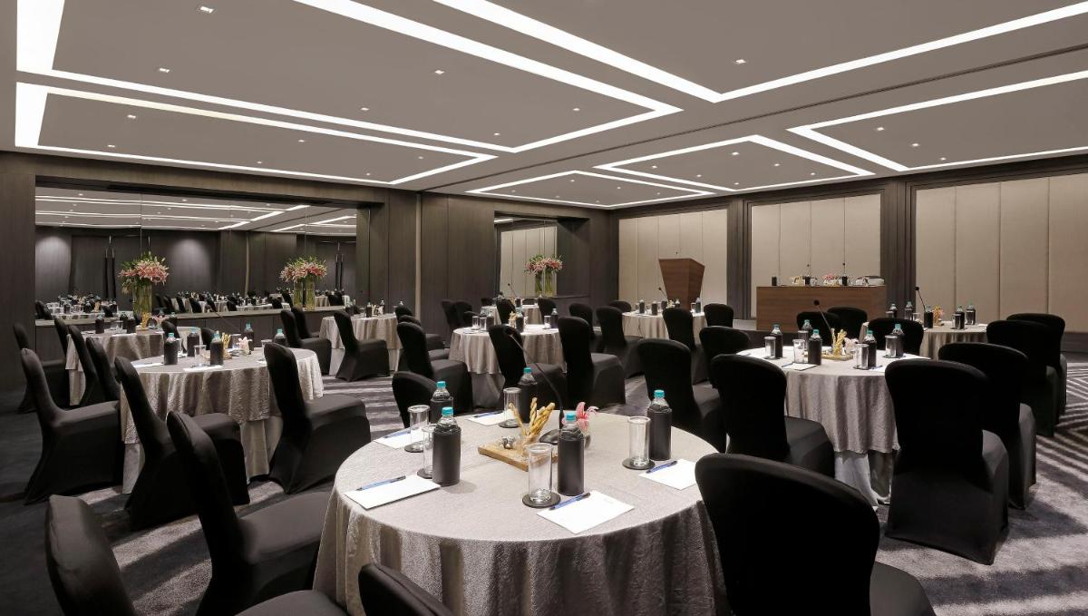 a conference room with tables and chairs and a podium at Novotel Chennai Chamiers Road in Chennai