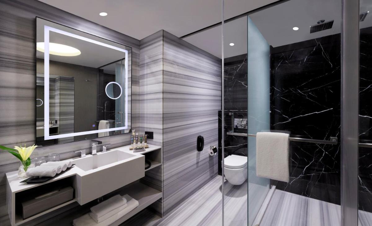 a bathroom with a sink and a mirror at Novotel Chennai Chamiers Road in Chennai