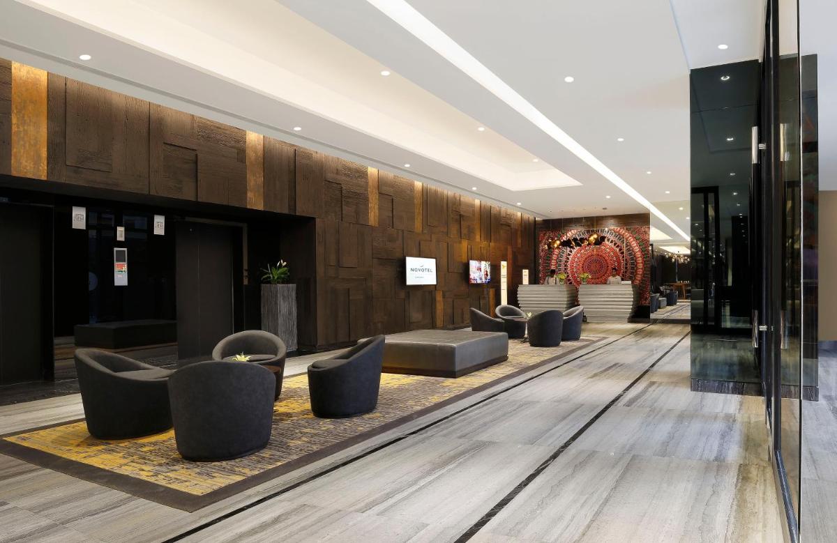 a lobby with a row of couches and chairs at Novotel Chennai Chamiers Road in Chennai +127 photos