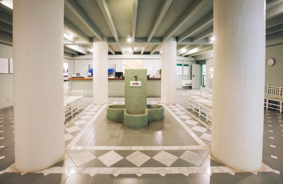 un vestíbulo con columnas y una fuente en el medio en Hotel Caldas, en Caldes de Boí 50 fotos más