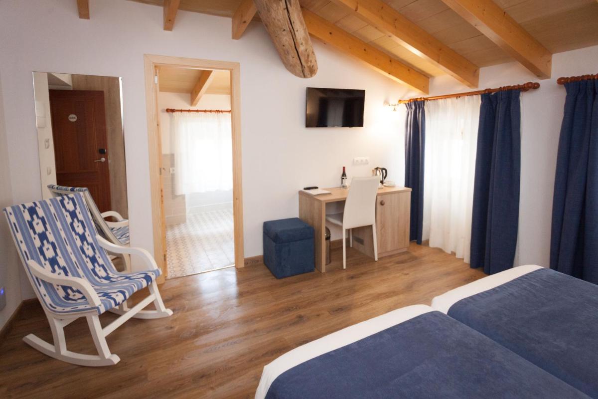 Un dormitorio con una cama, un escritorio y una silla. en Hotel El Guía, en Sóller