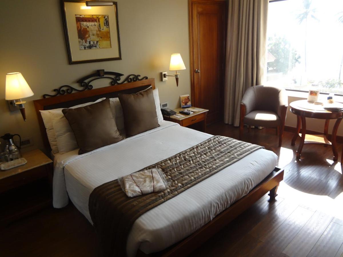 a hotel room with a large bed and a table at Sun-n-Sand Mumbai Juhu Beach in Mumbai
