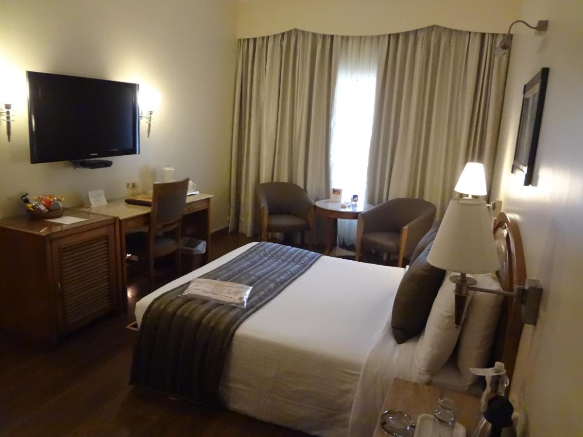 a hotel room with a bed and a desk and a television at Sun-n-Sand Mumbai Juhu Beach in Mumbai