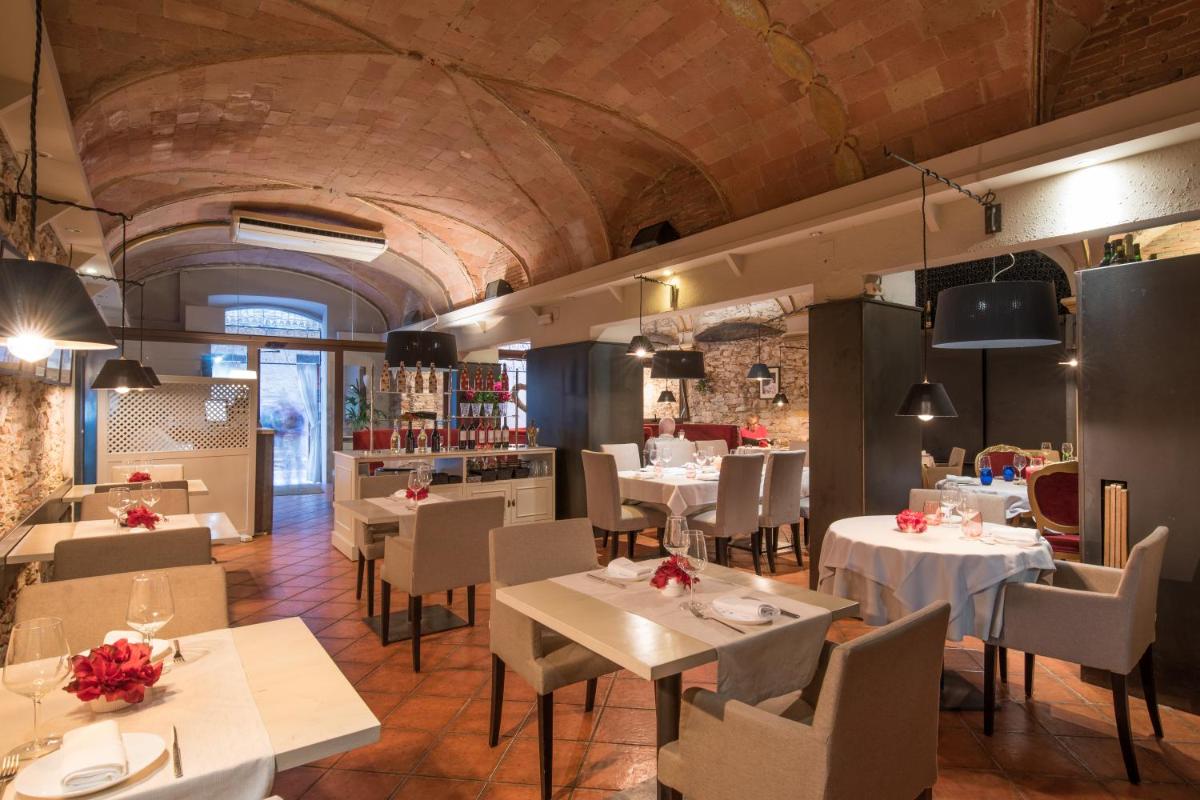 Un restaurante con mesas y sillas en una habitación. en Hotel-Spa Classic Begur, en Begur