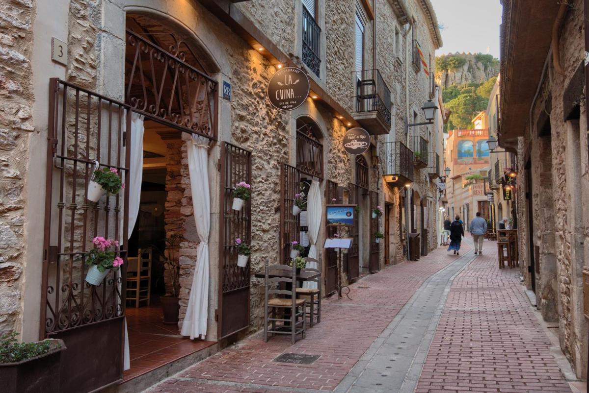un callejón en un viejo pueblo con gente caminando por él en Hotel-Spa Classic Begur, en Begur