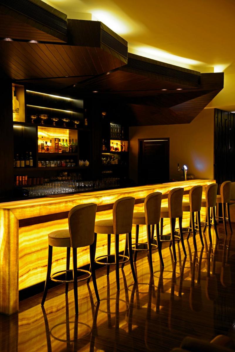 a bar with chairs and a long wooden counter at Sun-n-Sand Mumbai Juhu Beach in Mumbai