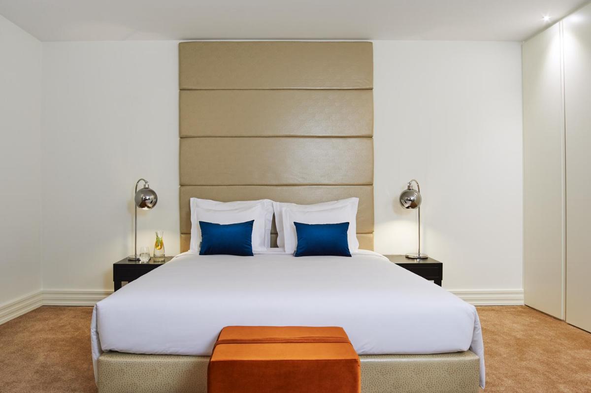 um quarto com uma grande cama branca com travesseiros azuis em Convento do Seixo Boutique Hotel & Spa no Fundão mais 75 fotografias