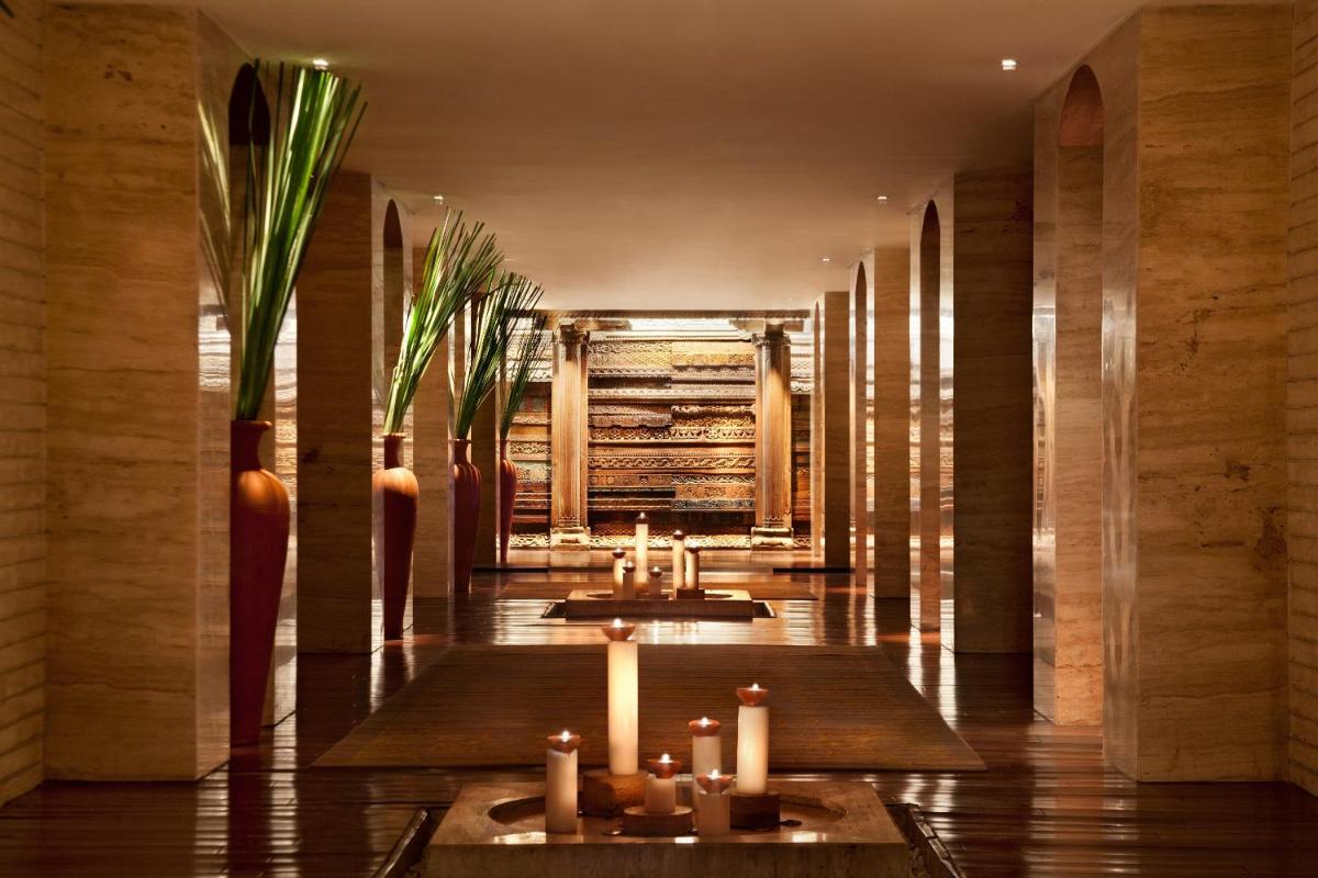 a lobby with candles and tables in a building at The Leela Ambience Convention Hotel Delhi in New Delhi