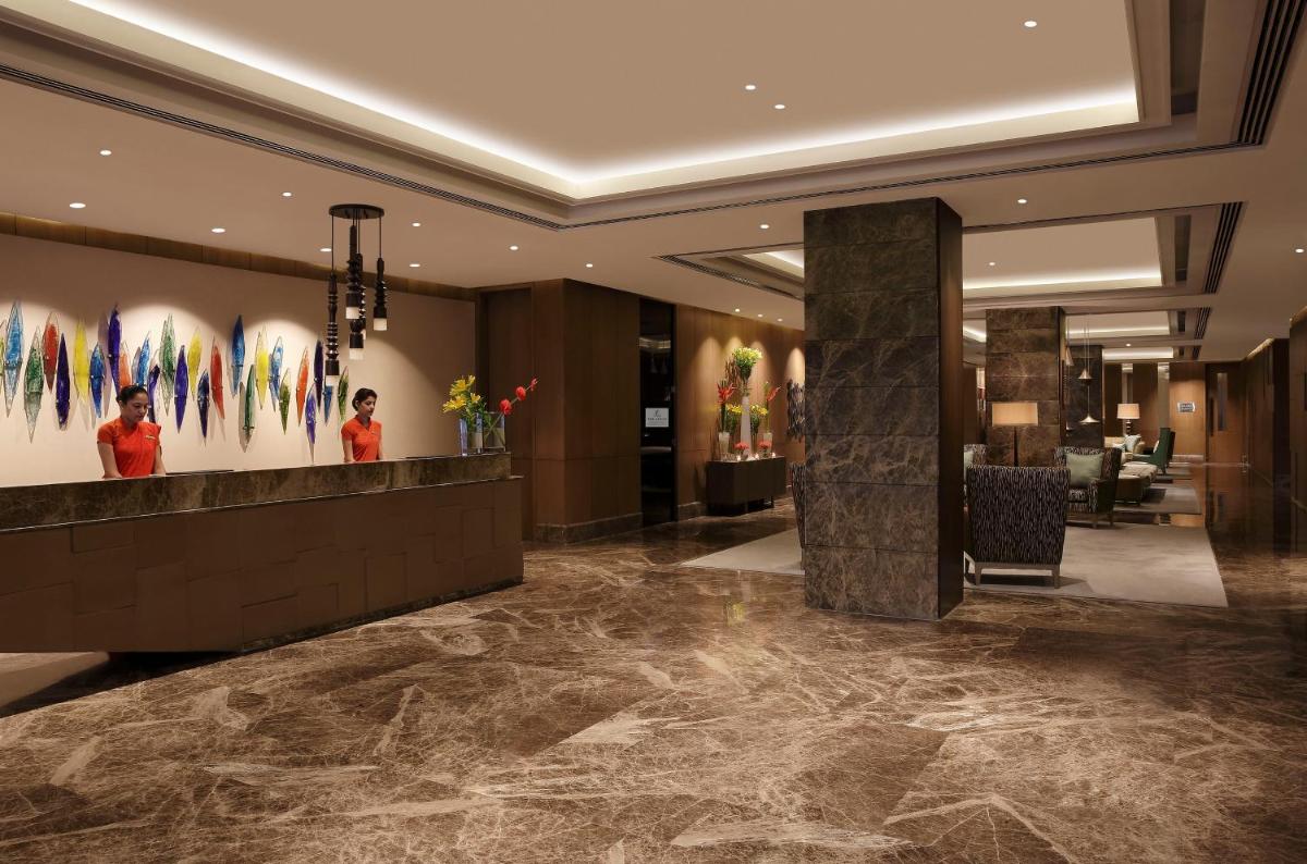 a lobby of a hotel with a reception desk at The Leela Ambience Convention Hotel Delhi in New Delhi