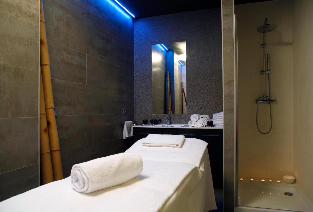 baño con 2 camas, lavabo y espejo en Apartahotel & Spa Jacetania, en Jaca
