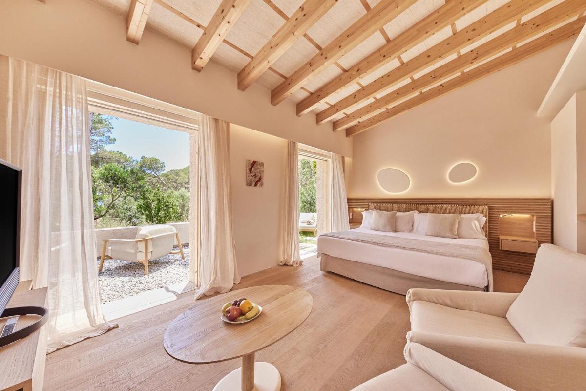 Un dormitorio con una cama, un sofá y un televisor. en Pleta de Mar, Grand Luxury Hotel by Nature - Adults Only, en Canyamel