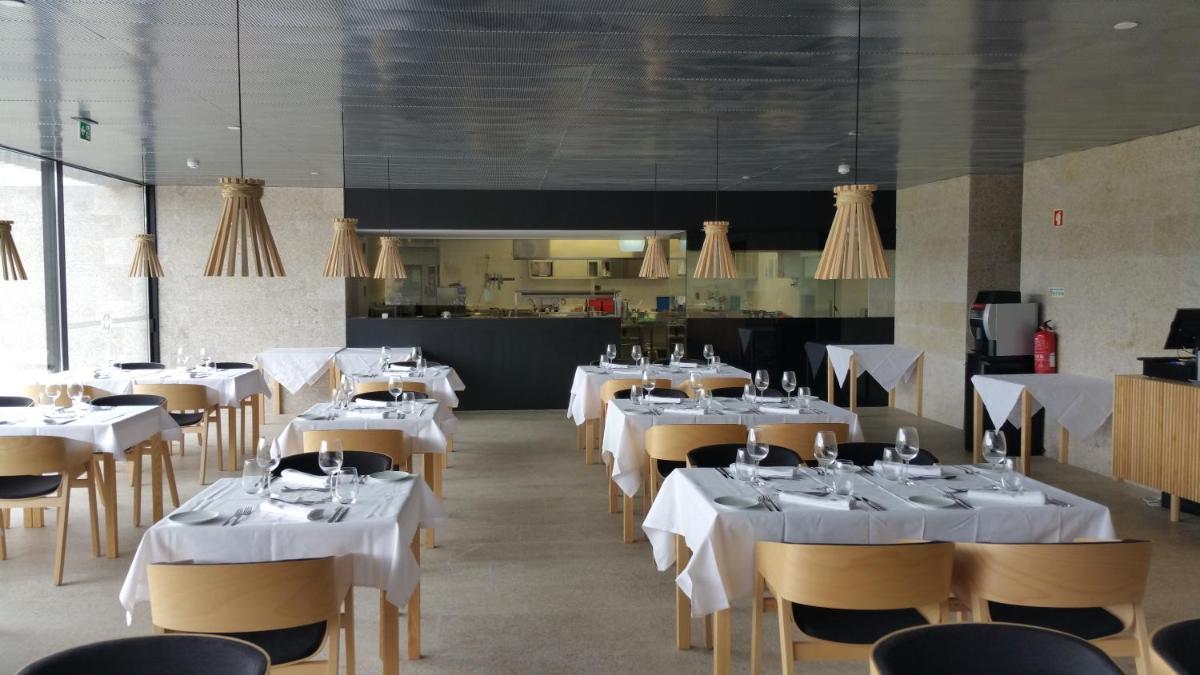 uma sala de jantar com mesas e cadeiras com toalha de mesa branca em Cró Hotel Rural em Rapoula do Côa