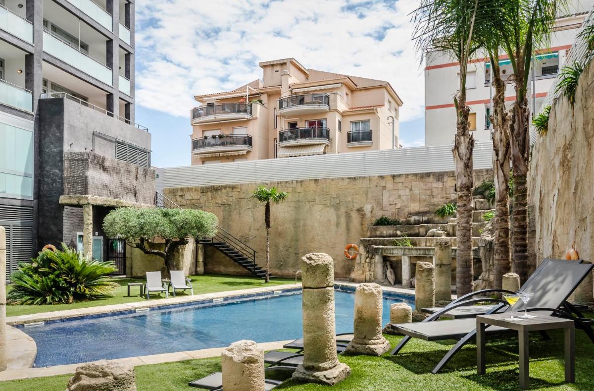 una piscina frente a un edificio en Exe Cunit Suites & Spa, en Cunit